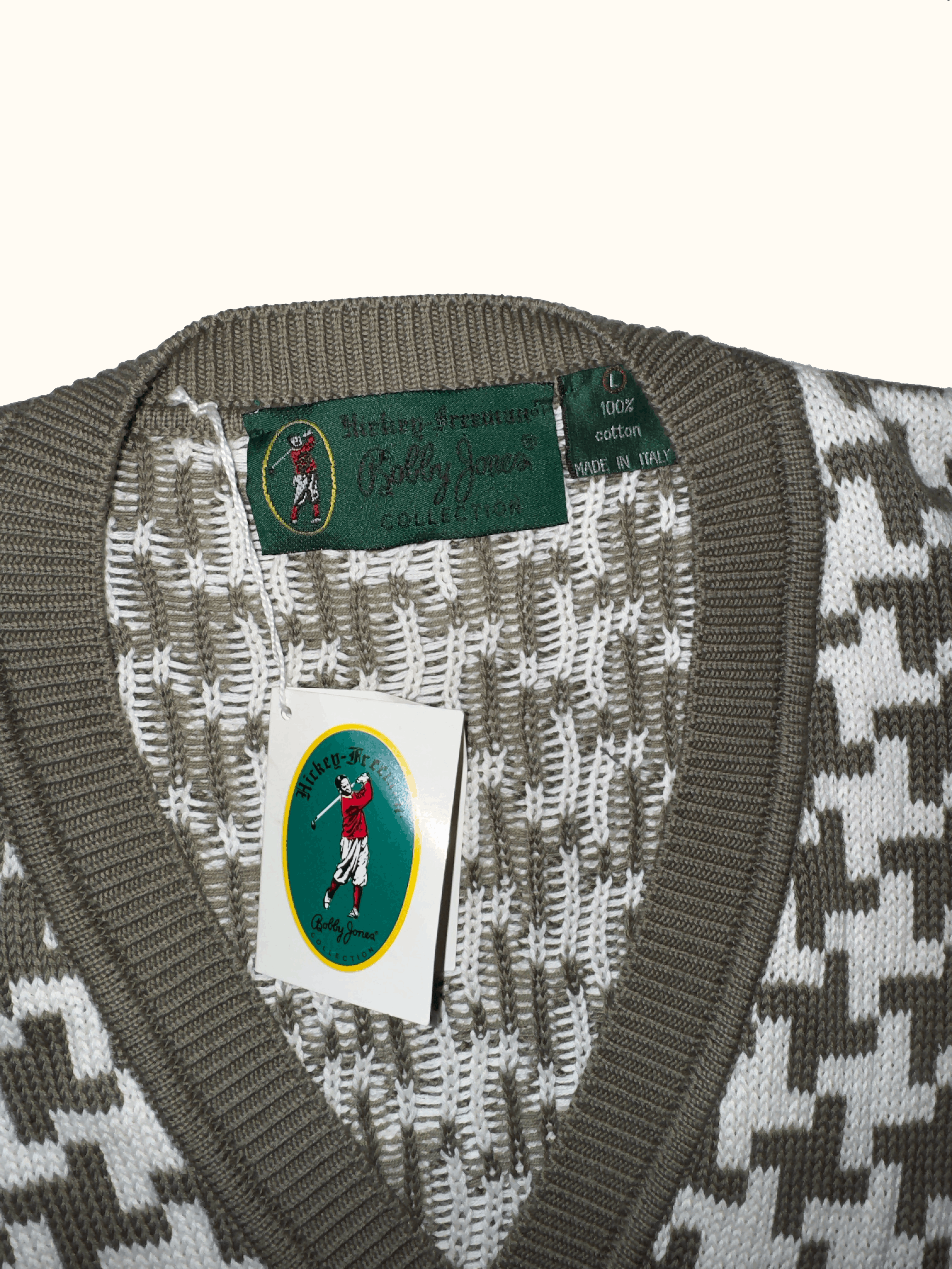 Close-up of a patterned sweater with a brand label and tag on a white background
