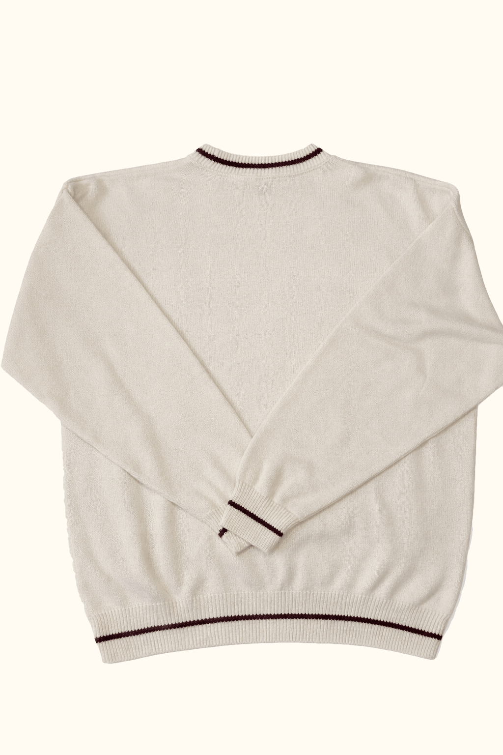 White sweater with black trim on a white background