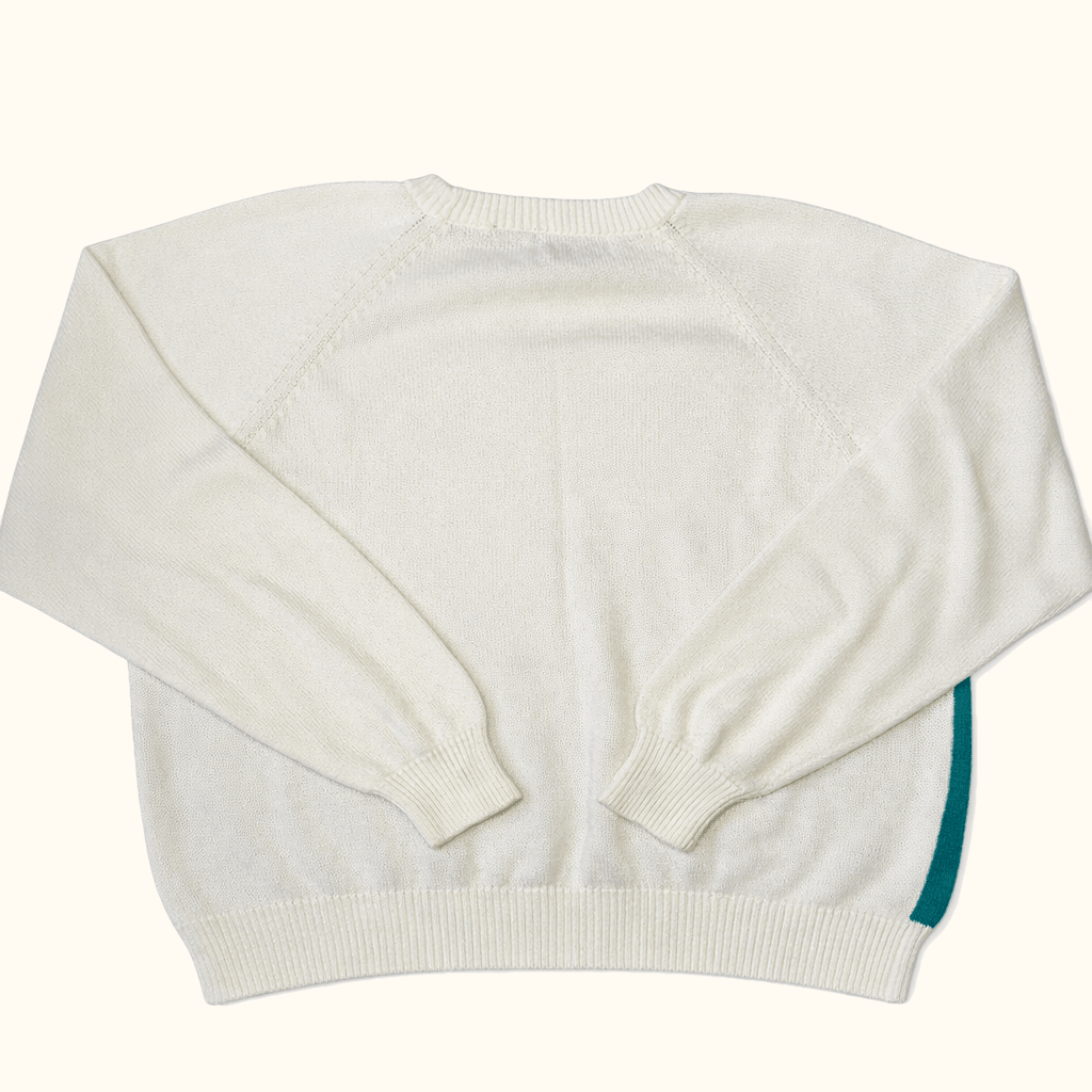 White cropped sweater with a green sleeve on a white background