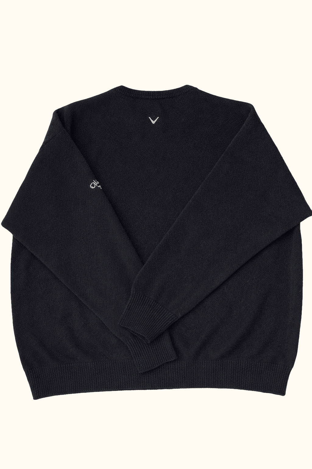 Black sweater with a small logo on a white background