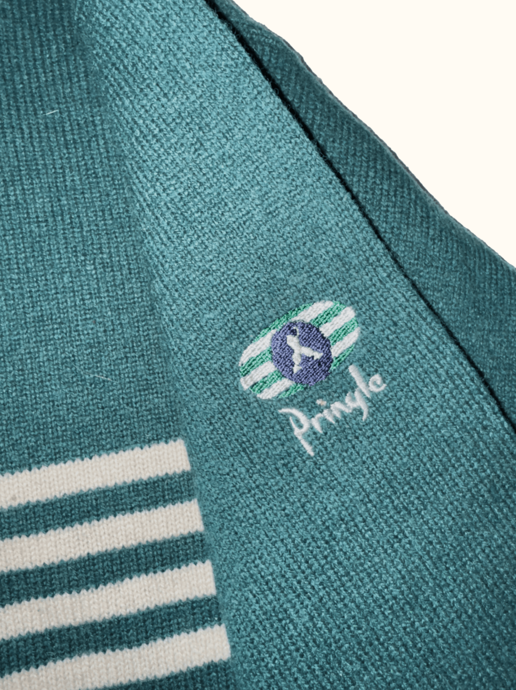 Teal sweater with white stripes and Pringle logo on a white background