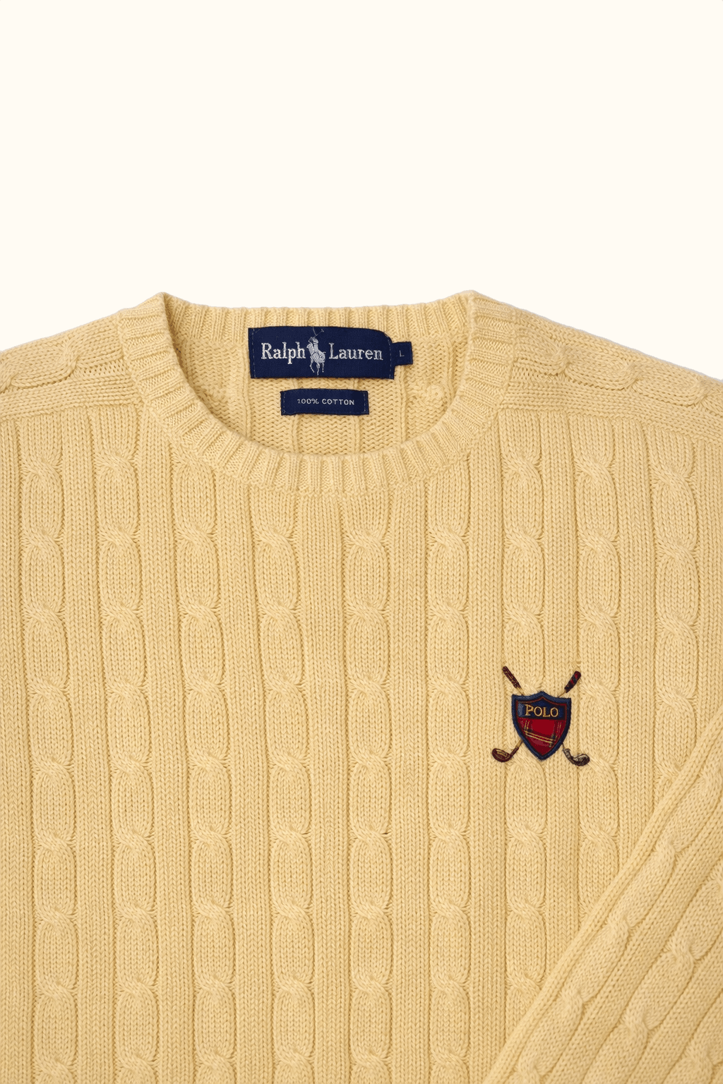 Beige cable knit sweater with Polo Ralph Lauren logo and embroidered emblem on a white background